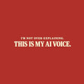 Black tee with cream text reading I'M NOT OVER-EXPLAINING. above larger bold text THIS IS MY AI VOICE. with a muted red underline beneath AI VOICE. Artwork shown on the Red garment colour.