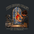 Arched stained-glass window, dark lead framework, blue-gray panes. A dark-haired woman fits a glowing red-orange flame-shaped glass piece into the center by hand. A metal machine sits at left. Text: THE SECOND DRAFT arched above, IS HUMAN below. Artwork shown on the Black garment colour.